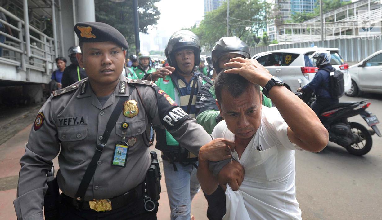 Terduga copet menutupi kepalanya dengan tangan saat akan diamankan menuju Mapolda Metro Jaya di Jalan Jenderal Sudirman, Jakarta (2/4). Polisi mengamankan tiga terduga copet. (Merdeka.com/Arie Basuki)