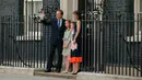 David Cameron didampingi istri Samantha dan ketiga anaknya, melambaikan saat akan meninggalkan kantornya, 10 Downing Street, London, Rabu (13/7). David Cameron mundur dari jabatannya sebagai PM Inggris pasca referendum Uni Eropa. (AFP PHOTO/Adrian DENNIS)