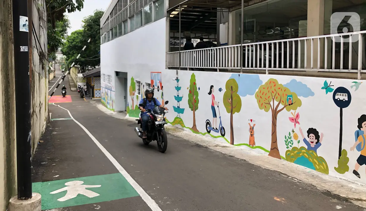 Pengendara sepeda motor melintas di depan mural dan akses khusus pejalan kaki di Jalan Darul Maarif, Jakarta Selatan, Rabu (11/3/2020). PT MRT Jakarta berkolaborasi dengan ITDP menata jalan-jalan sekitar stasiun untuk meningkatkan aksesibilitas warga sekitar. (Liputan6.com/Immanuel Antonius)