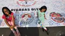 Dua orang anak saat berpose di atas spanduk yang berisi ribuan tanda tangan sebagai bentuk dukungan kepada Ahok, Jakarta. Foto diambil pada 9 November 2014. (Liputan6.com/Miftahul Hayat)