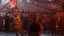 Polisi Afghanistan berjaga-jaga di dekat bangkai minibus yang meledak di dekat Kedubes Rusia di Kabul, Rabu (20/1). Ledakan itu menimbulkan asap hitam, sementara ambulans dan mobil pemadam kebakaran segera dikerahkan ke lokasi. (REUTERS/Ahmad Masood)