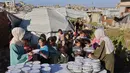 Lina Zeid dan Aya Zeid merupakan bagian dari banyak warga Gaza yang berusaha bertahan dan membantu sesama di tengah situasi yang sangat rapuh, di mana bantuan kemanusiaan seringkali sulit mencapai wilayah utara. Tampak dalam foto, kakak beradik Palestina, Lina Zeid (kiri) dan Aya Zeid, membagikan paket makanan kepada anak-anak pengungsi sebagai kegiatan amal di daerah Al-Tuam, sebelah barat Jabalia, Jalur Gaza Utara pada Rabu 6 Mei 2026. (Omar AL-QATTAA/AFP)