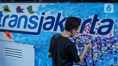 Penyandang disabilitas menggambar di salah satu bus Transjakarta di Kantor Pusat PT Transportasi Jakarta, Kamis (1/12/2022). Menyambut hari Disabilitas pada tanggal 3 Desember, sejumlah anak-anak berkebutuhan khusus melukis bus Transjakarta Mereka bebas melukis apa saja di badan bus yang telah disiapkan. (Liputan6.com/Faizal Fanani)