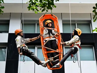 Mahasiswa mengikuti simulasi Vertical Rescue atau evakuasi vertikal selama latihan gempa bumi dan bencana di Universitas Syiah Kuala, Banda Aceh pada Selasa 21 Oktober 2025. (CHAIDEER MAHYUDDIN/AFP)