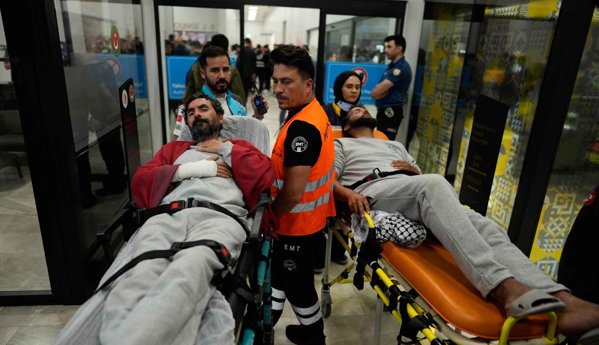 Para aktivis kemanusiaan Global Sumud Flotilla (GSF) diangkut dengan tandu beroda saat tiba di Bandara Istanbul, Turki, Kamis 21 Mei 2026. (AP Photo/Emrah Gurel)
