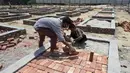 Para buruh bekerja membangun tempat kremasi di ladang kosong di New Delhi, India, Rabu (5/5/2021). Tsunami COVID-19 di India yang telah menembus 20 juta kasus menjadi sorotan dunia. (Money SHARMA/AFP)