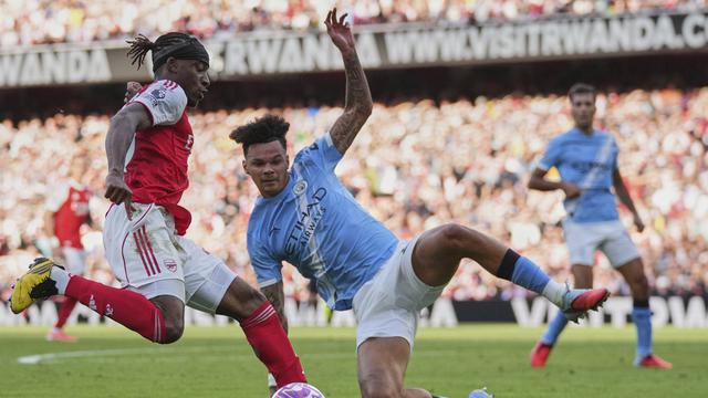 Noni Madueke (kiri) diadang Nico O'Reilly di laga Arsenal vs Manchester City di Emirates Stadium, Minggu (21/09/2025). (AP Photo/Kin Cheung)
