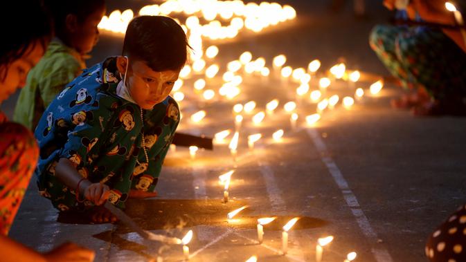 Seorang anak menyalakan lilin saat Festival Tazaungdaing di Yangon, Myanmar (29/11/2020). Festival Tazaungdaing, yang juga dikenal sebagai Festival Cahaya, jatuh pada hari bulan purnama di bulan kedelapan kalender tradisional Myanmar. (Xinhua/U Aung)