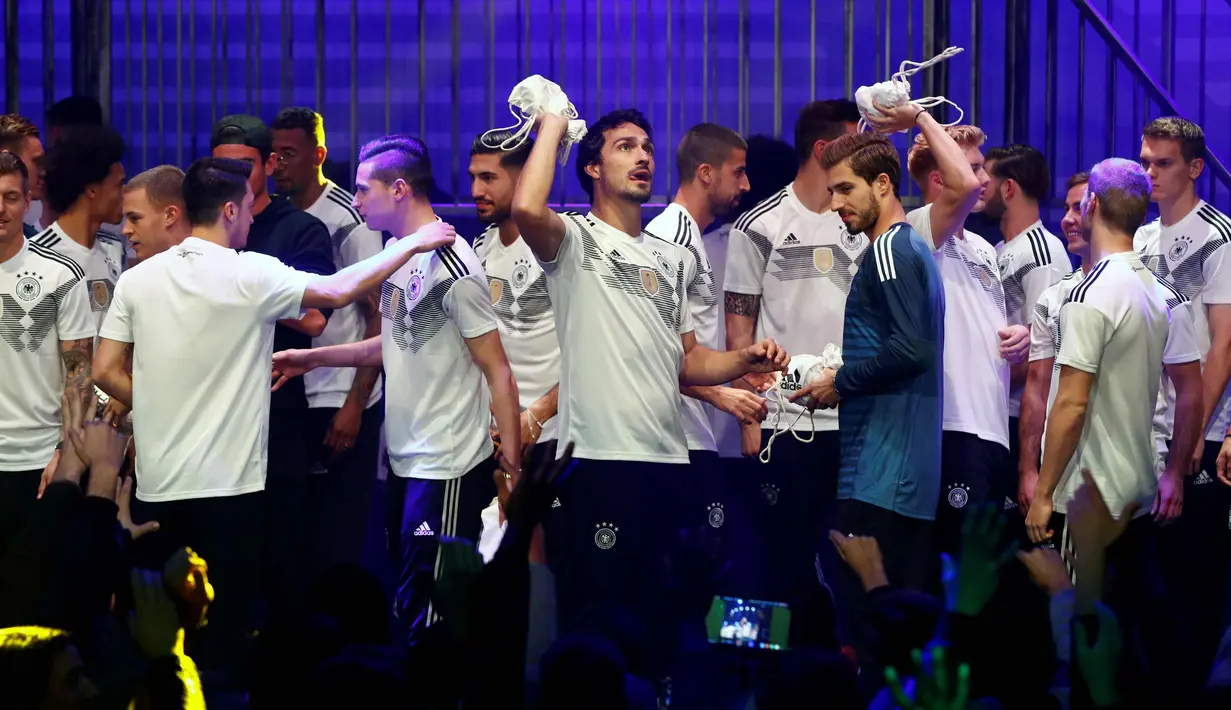 Pemain Timnas Jerman memberikan hadiah selama perkenalan jersey terbaru timnas Jerman untuk Piala Dunia 2018 di Berlin (7/11). Jersey ini terinspirasi dari kostum yang pernah dikenakan pada Piala Dunia 1990. (AFP Photo/Ganjil Andersen)