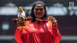 Atlet tolak peluru Indonesia, Suparniyati menunjukkan medali emas Asian Para Games 2018 di SUGBK, Jakarta, Senin (8/10). Suparniyati mencatat tolakan sejauh 10,75 meter. (Bola.com/Vitalis Yogi Trisna)