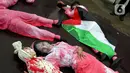 Salah satu dari mereka terlihat memeluk boneka dan diselimuti bendera Palestina, menggambarkan penderitaan anak-anak korban perang di Gaza. (Liputan6.com/Herman Zakharia)