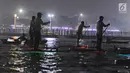 Sejumlah peserta mengikuti night paddling di kawasan ancol, Jakarta, Sabtu (18/5/2019). BPJS Ketenagakerjaan memperkenalkan olahraga air yang mulai banyak digemari oleh masyarakat yaitu Stand Up Paddleboard (SUP). (Liputan6.com/Herman Zakharia)
