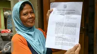 Warga menunjukan surat peringatan (SP1) yang diberikan Wali Kota Jakarta Utara, Rabu (30/3/2016). Sebanyak 310 rumah dan 347 kios di pasar ikan penjaringan akan dibongkar pihak Pemprov DKI. (Liputan6.com/Yoppy Renato)