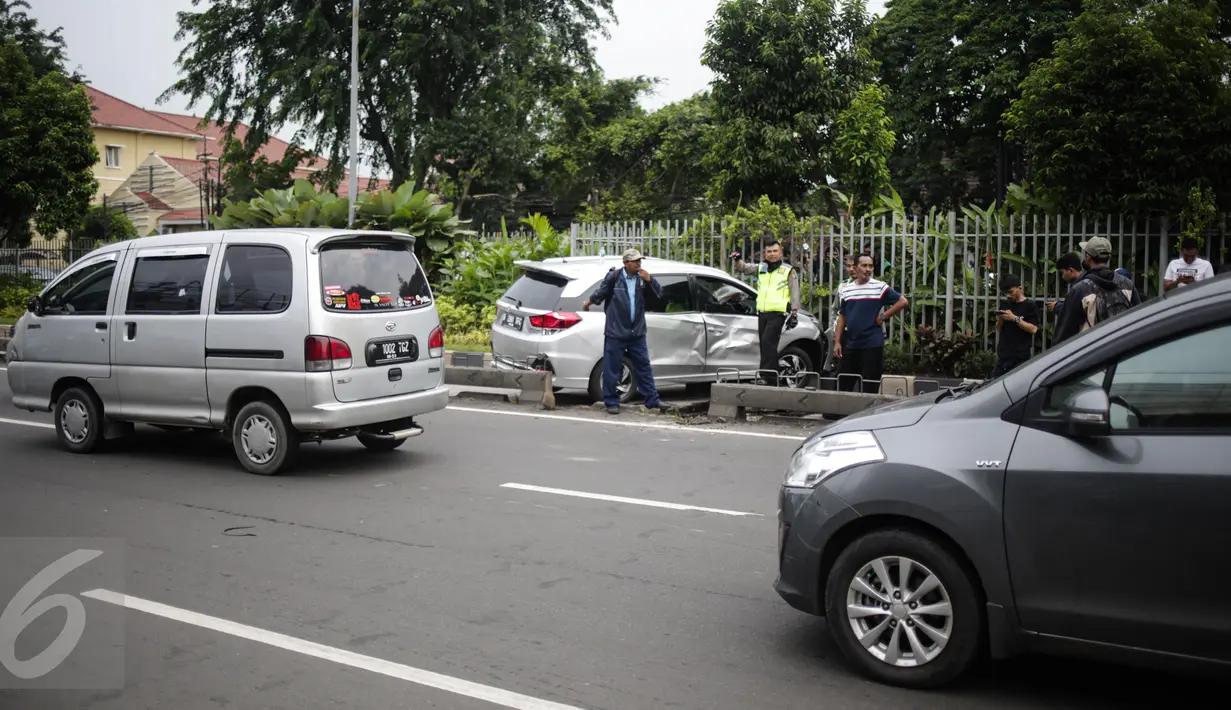 Pengendara lain melitas disamping mobil yang menabrak separator busway matraman arah kampung melayu, Jakarta, Sabtu (25/2). Akibat kecelakaan ini lalu lintas kawasan jalan matraman mengarah kampung melayu tersendat. (Liputan6.com/Faizal Fanani)