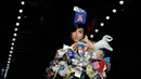 Model mengenakan busana rancangan Moschino dengan hiasan kepala berbentuk tempat tisu dalam Milan Fashion Week Autumn/Winter 2017 di Milan, Italia, (23/2). (AFP Photo / Marco Bertorello)