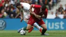 Penyerang Swiss, Xherdan Shaqiri, berebut bola dengan gelandang Portugal, Ruben Neves, pada laga UEFA Nations League di Estadio Do Dragao, Porto, Kamis (6/6) dini hari WIB. Portugal menang 3-1 atas Swiss. (AP/Armando Franca)