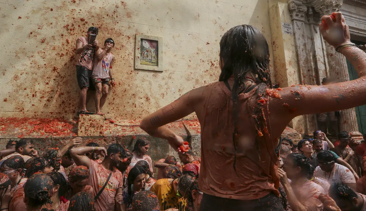 La Tomatina merupakan perang tomat di mana setiap peserta saling melemparkan tomat sebagai senjatanya. (AP Photo/Alberto Saiz)