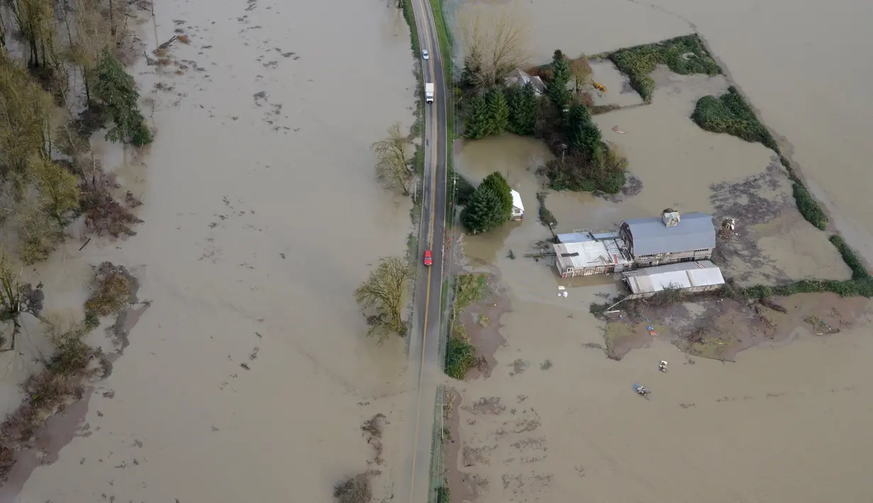 Jalanan yang tertutup air mengganggu kendaraan yang akan melintasi kawasan dekat sungai Snoqualmie, Washington, Kamis (19/11/2015). Bencana ini menewaskan sedikitnya tiga orang. (REUTERS / David Ryder)