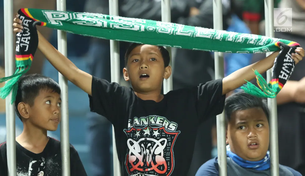 Suporter cilik tim Elang Jawa membentangkan syal saat menyaksikan laga uji coba Timnas Indonesia u-19 melawan PSS Sleman di Stadion Maguwohardjo, Sleman, Sabtu (12/8). Laga berakhir imbang 2-2. (Liputan6.com/Helmi Fithriansyah)