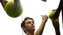 Petenis Amerika Serikat, Taylor Fritz menandatangi bola yang disodorkan penggemarnya setelah mengalahkan Gael Monfils dari Prancis dalam babak kedua  turnamen Australia Terbuka di Melbourne, Rabu (16/1). (AP Photo/Andy Brownbill)