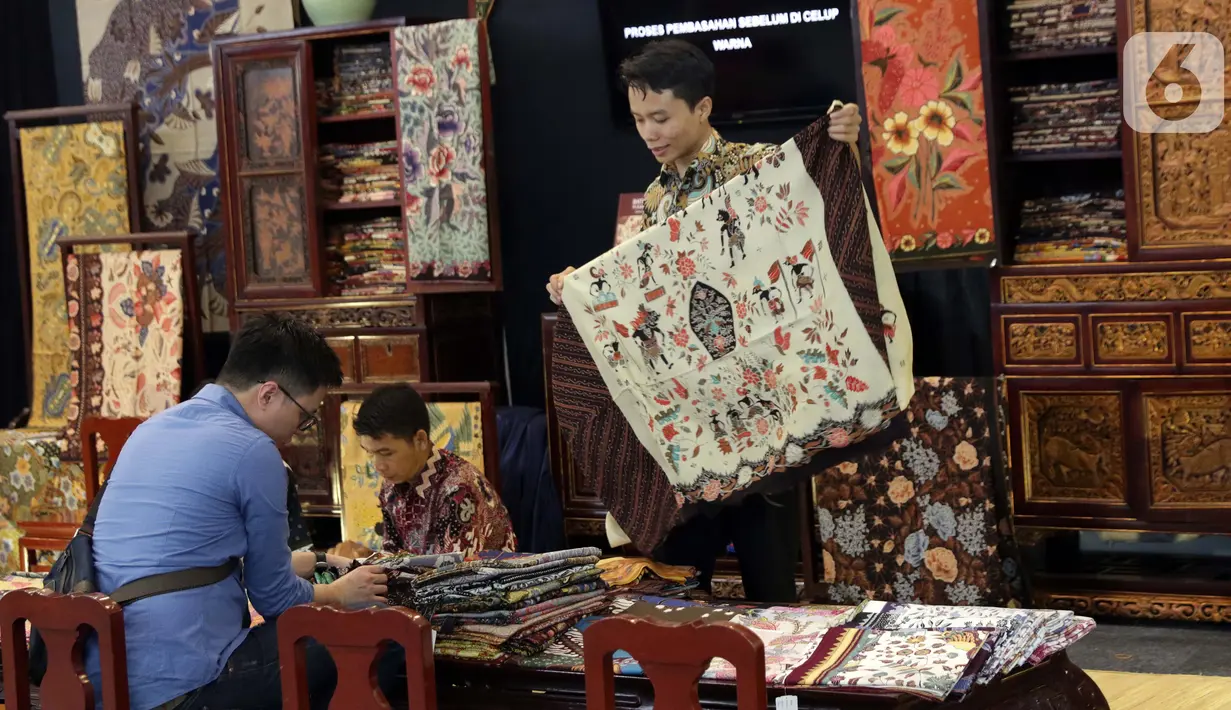 Pengunjung memilih koleksi batik yang dipamerkan pada Interior and Craft (ICRA) Exhibition 2019 yang dihelat di Hall A Jakarta Convention Center (JCC), Senayan, Jakarta, Minggu (6/10/2019). Ratusan motif batik dari berbagai daerah dipamerkan pada ajang ini. (Liputan6.com/Helmi Fithriansyah)