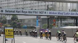 Para pebalap melintasi jembatan penyebrangan dengan jarak 1km sebelum garis finish pada ajang Tour de Jakarta di Jakarta, Sabtu (30/7/2016). (Bola.com/Nicklas Hanoatubun)