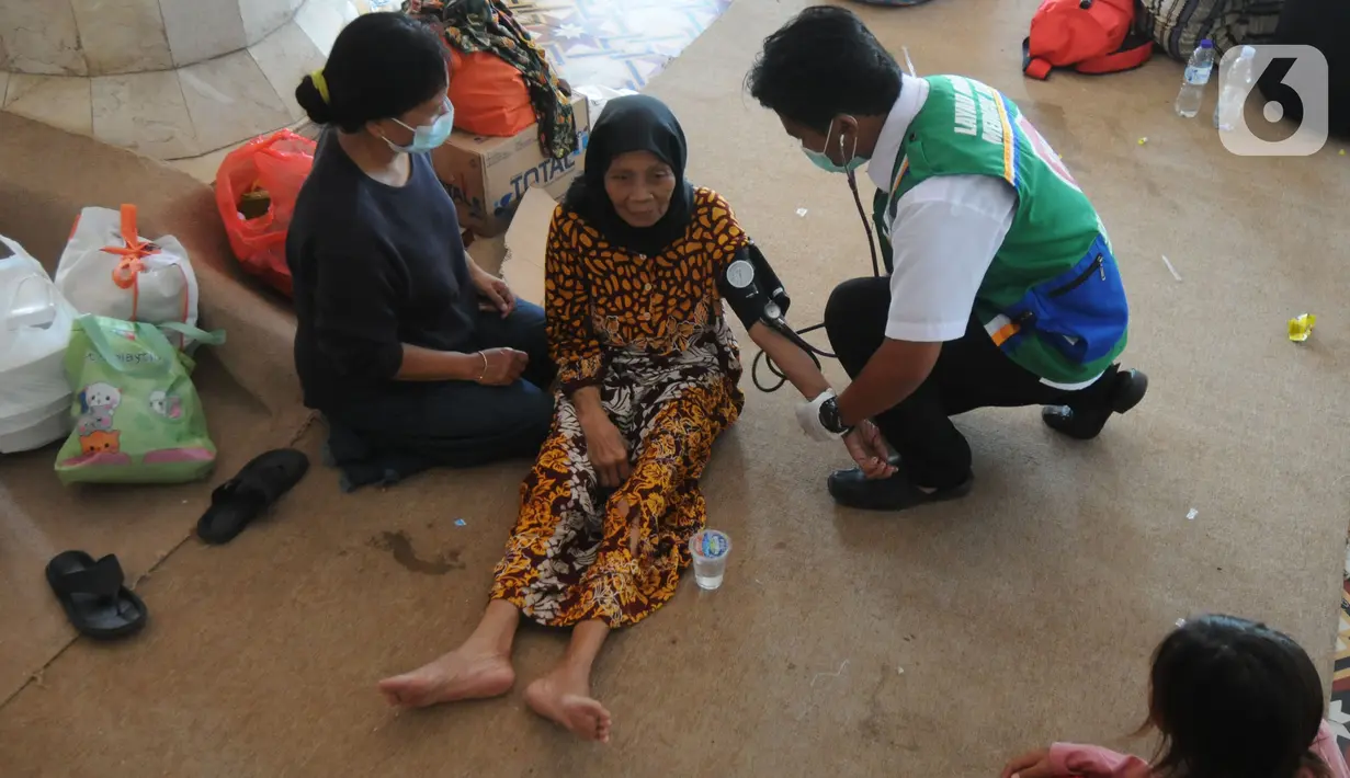 Paramedis memeriksa kesehatan pengungsi korban ledakan kilang minyak di Pendopo Kabupaten Indramayu, Senin (29/03/2021). Sekitar 900 warga saat ini mengungsi dari lima desa terdampak ledakan kilang minyak Balongan.  (merdeka.com/Arie Basuki)