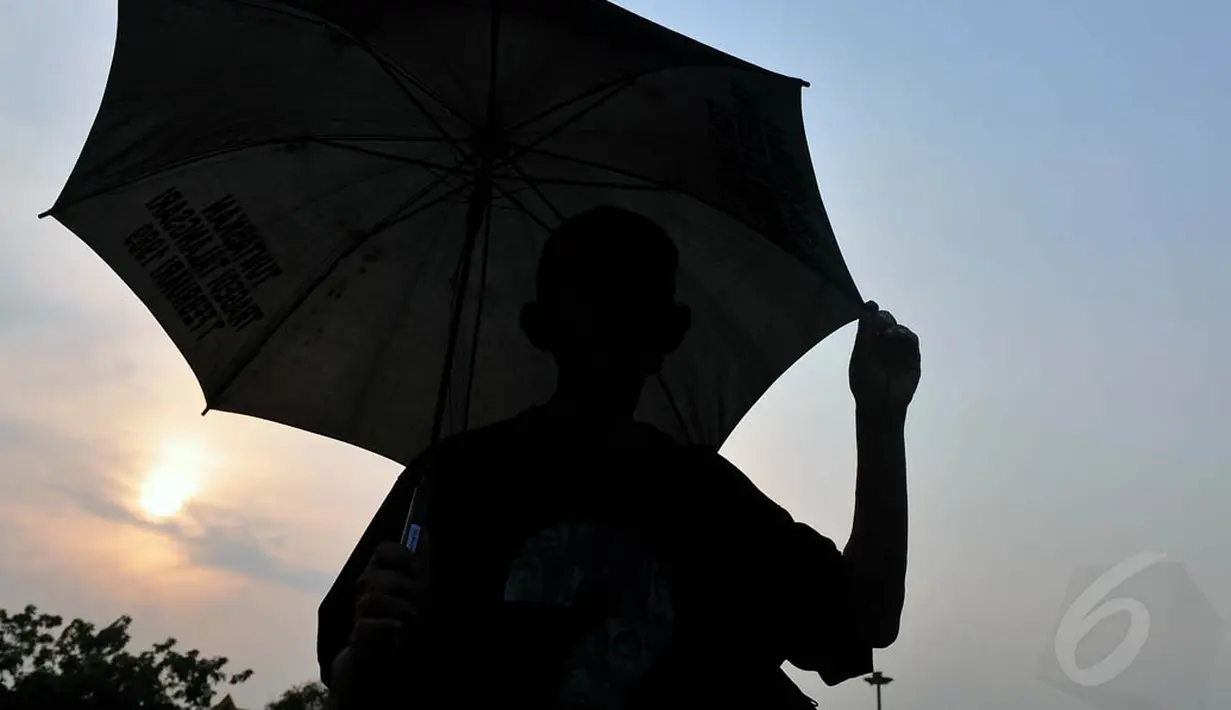 Para aktivis mengenakan baju hitam bertulisan "Aksi Kamisan" dan membawa payung hitam, Jakarta, (16/10/14). (Liputan6.com/Johan Tallo)