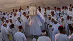 Pendeta Samaria mengangkat sebuah gulungan Taurat dalam upacara tradisional perayaan Festival Shavuot di Gunung Gerizim, Tepi Barat, Minggu (28/6/2020). Hari Raya Shavuot adalah untuk memperingati hari Allah memberikan Taurat kepada Musa dan bangsa Israel di Gunung Sinai. (Xinhua/Ayman Nobani)
