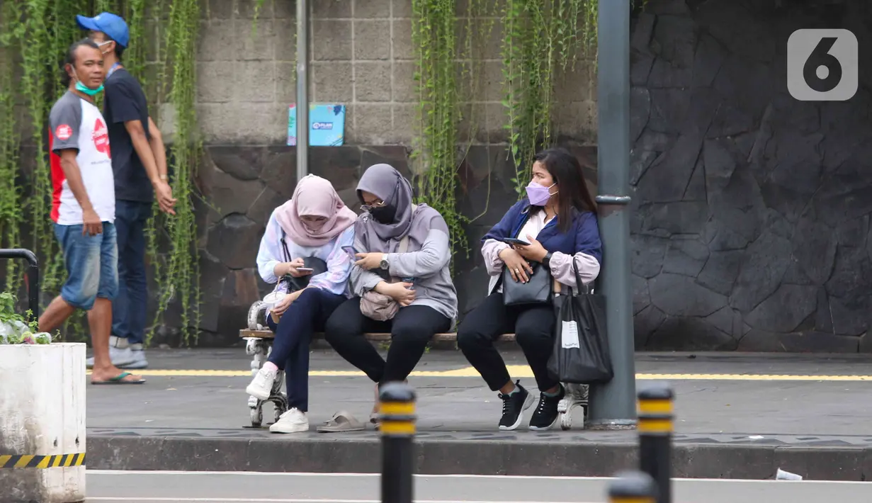 Pekerja sedang menunggu transportasi umum di kawasan Jalan Mh Thamrin, Jakarta, Rabu (25/5/2022). Kawasan Jabodetabek memberlakukan PPKM Level 1 mulai 24 Mei selama dua pekan mendatang. Selama kebijakan berlaku, karyawan di perusahaan sektor non esensial diperbolehkan bekerja dari kantor atau work from office (WFO) dengan kapasitas 100 persen. (Liputan6.com/Herman Zakharia)
