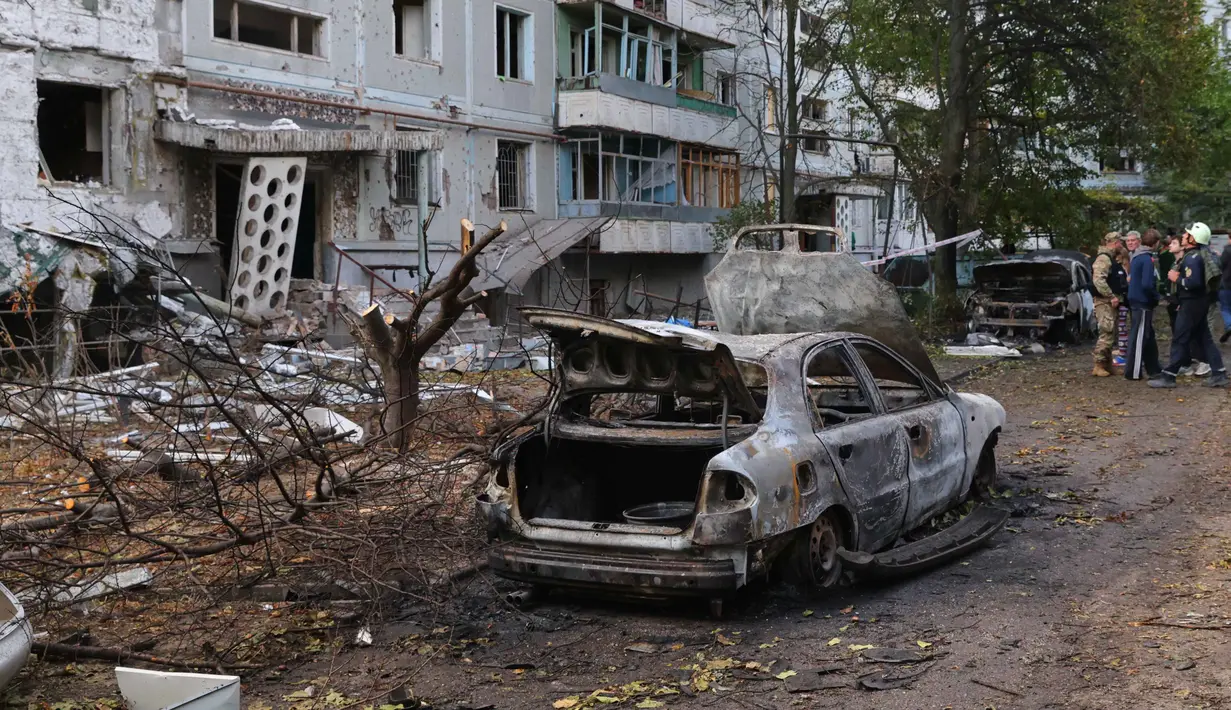 Di Zaporizhzhia, satu orang tewas dan 10 lainnya luka-luka, sementara lebih dari 70 ribu warga sempat kehilangan pasokan listrik untuk sementara. Tampak dalam foto, mobil-mobil yang terbakar dan bangunan tempat tinggal yang rusak terlihat setelah serangan Rusia di Zaporizhzhia, Ukraina, Minggu 5 Oktober 2025. (AP Photo/Kateryna Klochko)