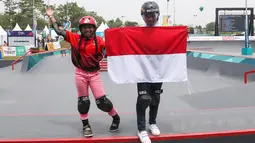 Skateboarder putri Indonesia Aliqqa Novvery (kiri) dan Bunga Nyimas mengibarkan bendera merah putih usai mengikuti final skateboard kelas taman putri Asian Games 2018 di Palembang, Sumatera Selatan, Rabu (29/8). (ANTARA FOTO/INASGOC/M N Kanwa/thv/18)