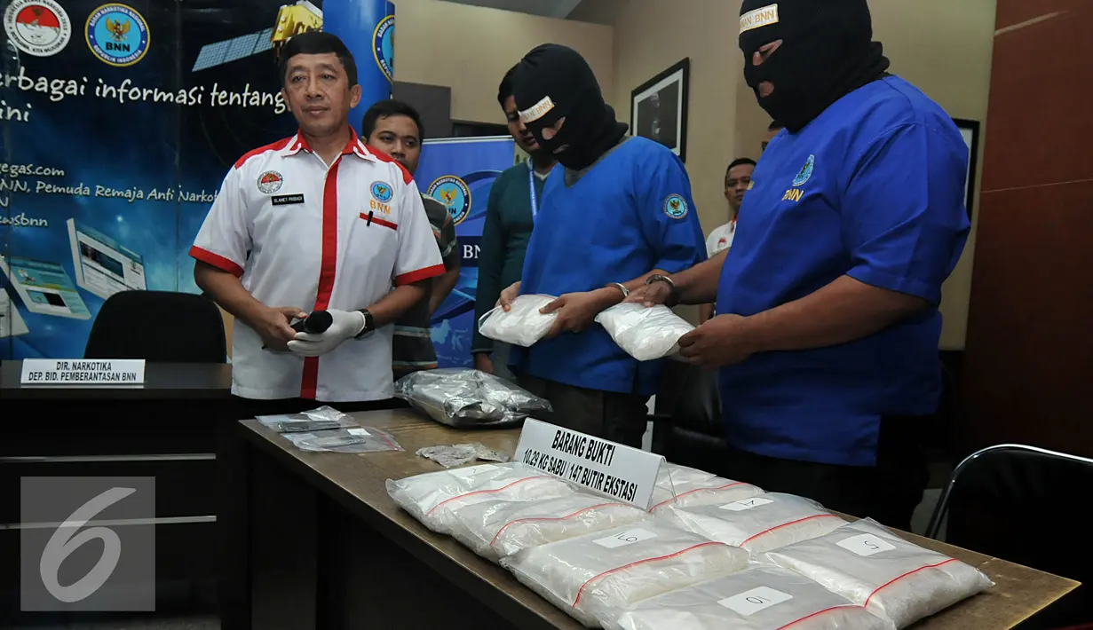 Dua orang tersangka penyelundupan narkotika asal Malaysia memperlihatkan barang bukti berupa sabu dan ekstasi, Jakarta, Rabu (17/6/2015). Tersangka yang merupakan ayah dan anak yaitu M (48), dan RMR (21) telah diamankan BNN. (Liputan6.com/Johan Tallo)