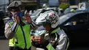 Polisi melakukan sosialisasi penggunaan masker kepada pengendara sepeda motor di kawasan Depok, Jawa Barat, Senin (20/7/2020). Setelah sosialisasi, Pemkot Depok akan menerapkan sanksi denda kepada warga yang melanggar. (Liputan6.com/Immanuel Antonius)