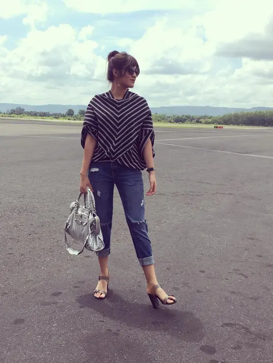 Terlihat berada di lapangan terbang, Raisa tampil dengan Ripped Jeansnya yang dipadukan dengan blouse bermotif lurik. Dengan bun hair, sun glasses dan anting panjangnya, tampilan Raisa trendy banget saat itu. (Instagram/raisa6690)