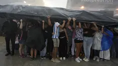 Para penggemar mencari perlindungan dari hujan deras saat mereka menunggu untuk memasuki Stadion DRV PNK, markas tim sepak bola MLS Inter Miami, untuk sebuah acara yang menghadirkan superstar internasional Lionel Messi satu hari setelah tim menyelesaikan penandatanganannya melalui musim 2025 di Fort Lauderdale, Florida, Amerika Serikat, Minggu (16/7/2023). (AP Photo/Rebecca Blackwell)