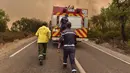 <p>Petugas pemadam kebakaran berupaya memadamkan kebakaran hutan yang disebabkan suhu ekstrem di Larache, Maroko utara, Jumat (15/7/2022). Petugas pemadam kebakaran dan militer berjuang untuk menahan beberapa kebakaran hutan di Maroko utara, ketika ratusan warga mengungsi dari rumah mereka karena kobaran api yang melanda petak besar hutan pinus. (AP Photo)</p>