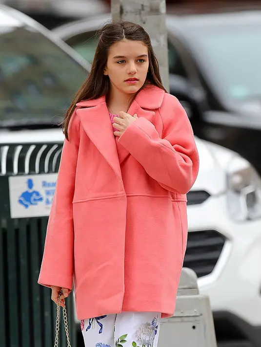 Suri Cruise diketahui sering sekali keluar bersama teman-teman layaknya remaja pada umumnya. Gadis berambut brunette ini ternyata lebih suka dengan gaya yang casual namun tetap elegan. Dengan balutan coat pink, pesona kecantikan Suri bikin hati netizen luluh.(Liputan6.com/IG/suricruise.official)