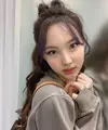 Nayeon mewarnai rambut panjangnya menjadi cokelat. Menariknya, poninya diwarnai dengan ungu. Gaya rambut ponytail setengah rambut yang acak. Instagram @twicetagram