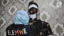 Pekerja memasang masker pasa manekin untuk dipajang di Butik Elemwe, Jakarta, Selasa (22/12/2020). Masker batik betawi ini dibanderol mulai dari Rp 20.000 hingga Rp 40.000 per buah tergantung jenis dan tingkat kerumitan pembuatan. (merdeka.com/Iqbal S. Nugroho)