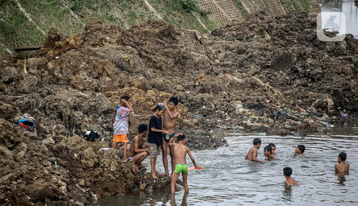 Anak-anak bermain di Sungai Ciliwung yang surut di kawasan Bukit Duri, Jakarta, Sabtu (8/8/2020). Penyusutan debit air Sungai Ciliwung tersebut karena memasuki masa kemarau 2020 yang menurut BMKG akan mencapai puncaknya pada Agustus. (Liputan6.com/Faizal Fanani)