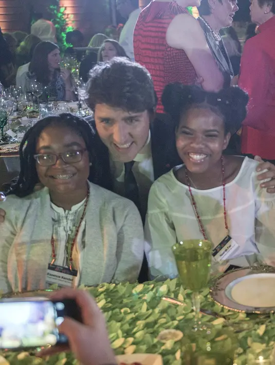 Perdana Menteri (PM) Kanada, Justin Trudeau berfoto bersama dua siswi SMA ketika menghadiri acara Fortune Most Powerful Women Summit 2017 di Washington, Selasa (10/10).(AFP Photo / Andrew CABALLERO-REYNOLDS)