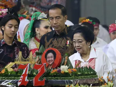 Ketua Umum PDIP Megawati Soekarnoputri memotong tumpeng pada HUT ke-72 didampingi Presiden Joko Widodo di Grand Sahid Jakarta, Rabu (23/1). Sejumlah politisi dan kader PDIP turut hadir dalam HUT ke-72 Megawati. (Liputan6.com/Angga Yuniar)