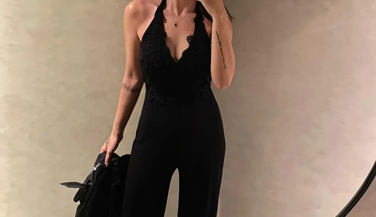 Dalam balutan jumpsuit dengan aksen renda dan halter neck, tampilan elegan berhasil diekspresikan.