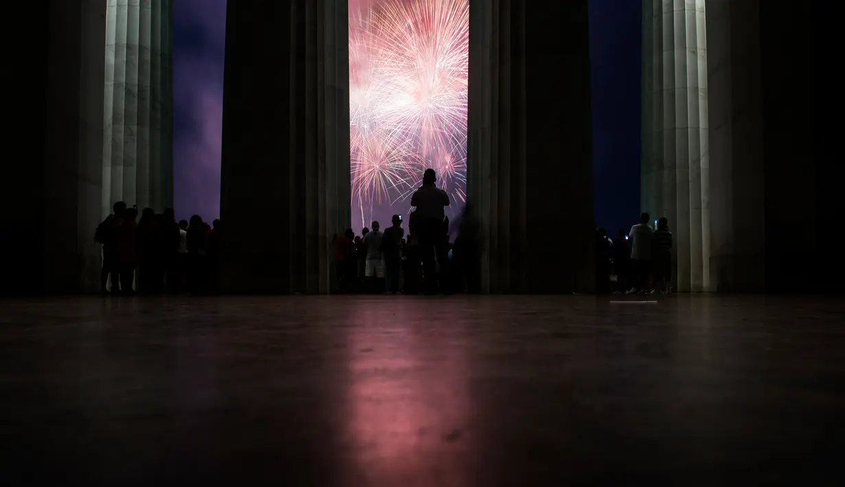 Sejumlah orang menonton kembang api saat perayaan hari kemerdekaan AS di Washington DC (4/7). Bertepatan tanggal 4 Juli warga Amerika Serikat merayakan Hari Kemerdekaan atau yang dikenal dengan Independence Day 4th July. (AFP Photo/Brendan Smialowski)
