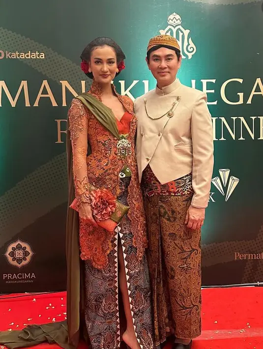 Atiqah mengenakan heels dengan model tertutup di bagian depan warna hitam. Serta membawa clutch anyaman warna serasi dengan kebayanya dan memiliki aksen bunga besar di bagian depan. [@atiqahhasiholan]