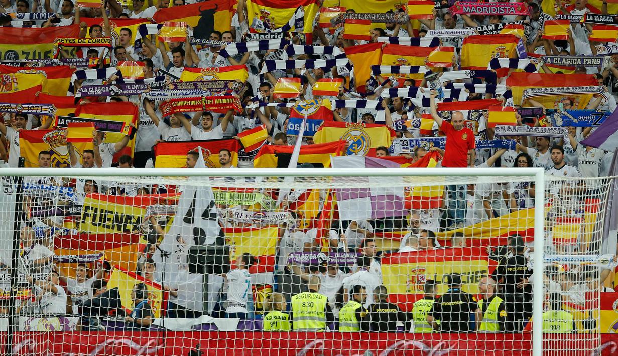 Suporter Real Madrid membentangkan bendera Spanyol saat pertandingan melawan Espanyol di Santiago Bernabeu, Spanyol (1/10). Espanyol sendiri juga berbasis di Catalonia, sama dengan Barcelona. ( AP Photo/Paul White)