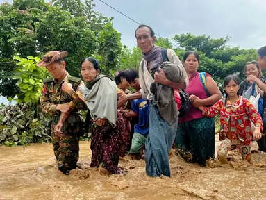 Warga berjalan melintasi banjir di Pyinmana di wilayah Naypyidaw, Myanmar, pada tanggal 13 September 2024. (Sai Aung MAIN/AFP)