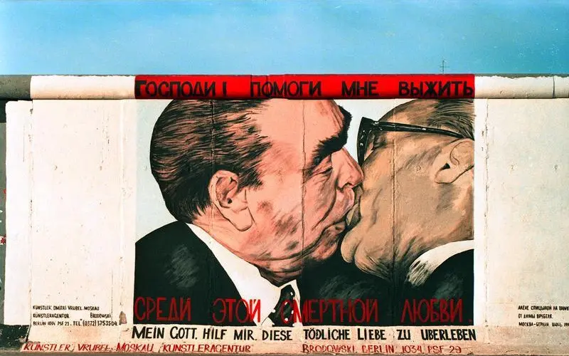 Mural Pemimpin Jerman Timur Erich Honecker berciuman dengan pemimpin Uni Soviet Leonid Brezhnev di Tembok Berlin pada masa Perang Dingin (Bundesarchiv/Joachim F Thurn via Wikimedia Commons)