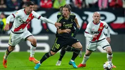 Pemain Real Madrid Luka Modric (tengah) berebut bola dengan pemain Rayo Vallecano Santi Comesana pada pertandingan sepak bola Liga Spanyol di Stadion Vallecas, Madrid, Spanyol, 7 November 2022. Rayo Vallecano mengalahkan Real Madrid dengan skor 3.2. (AP Photo/Manu Fernandez)